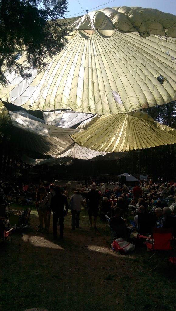 Parachutes billow in the breeze, shading the main stage.